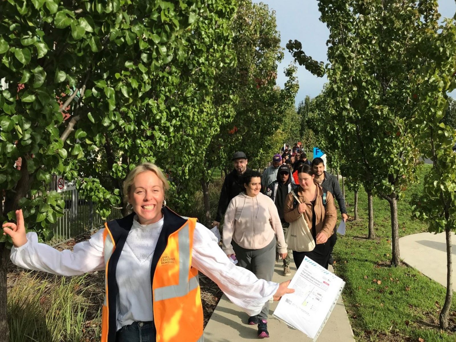 LXRP worker in hi-vis smiling and leading a group of students in Preston.