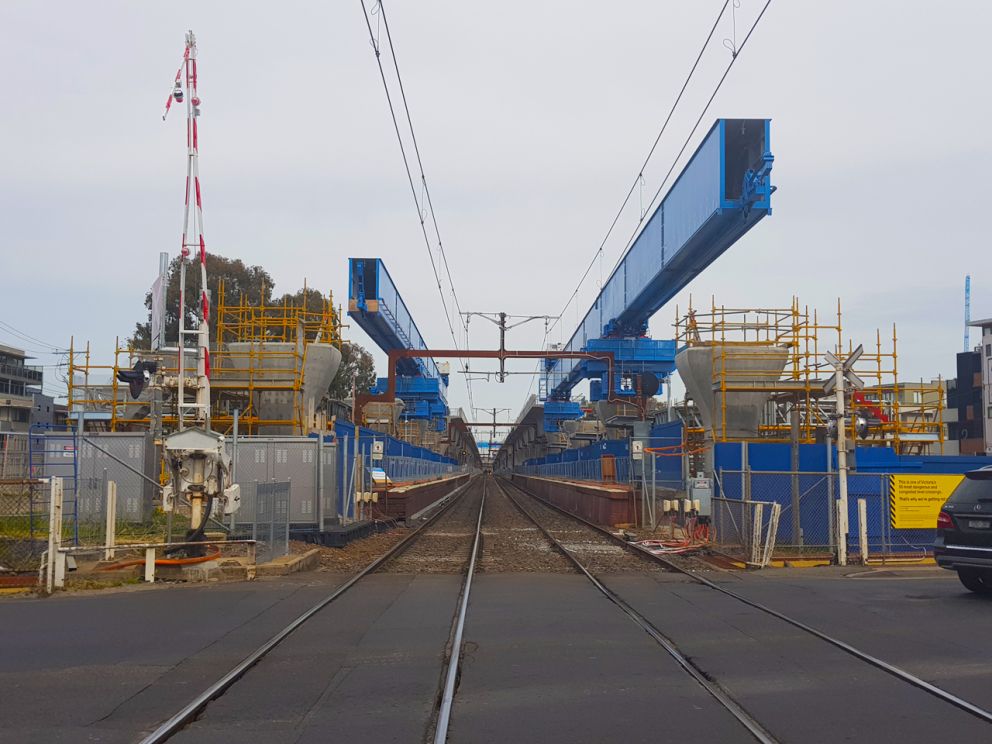 Large blue crane in rail corridor.