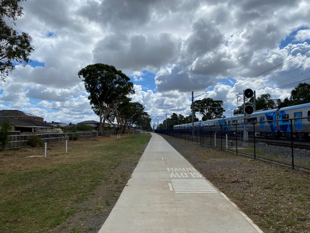 Shared user path on the Cranbourne Line featuring city bound train