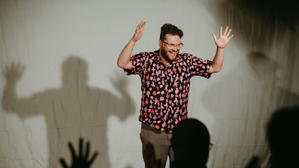 Image of a person standing on a stage doing sign language