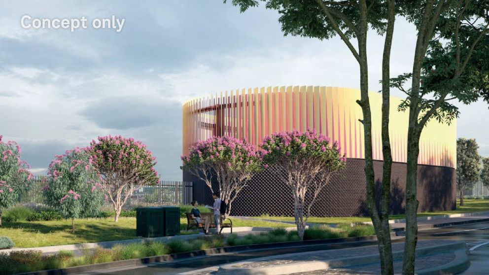 A render of a vibrant green area, with an oval-like strucutre surrounded by a yellow and pink finned exterior.