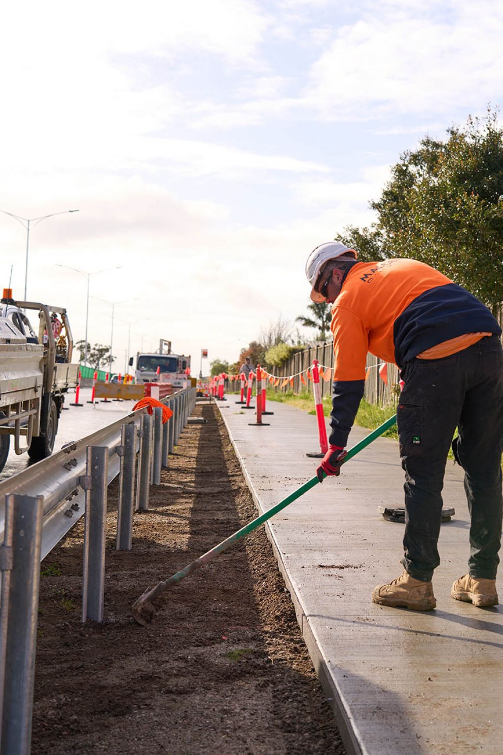 A worker carefully preparing the guardrail footing. That’s the bit that keeps the grass away for easy mowing