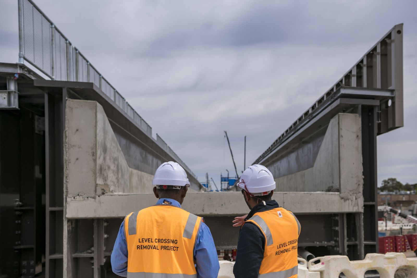 Two construction workers survey the progress of the steel girder at Webb Street. 
