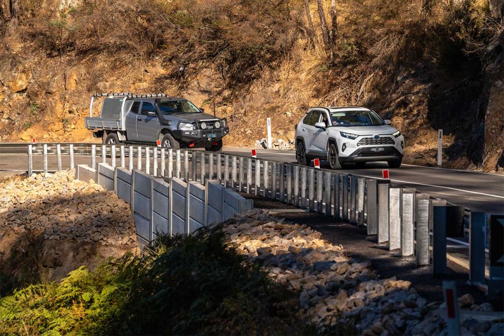 Trafffic moves past the site of the 2nd smaller landslip with the new retaining wall to stop future road failures