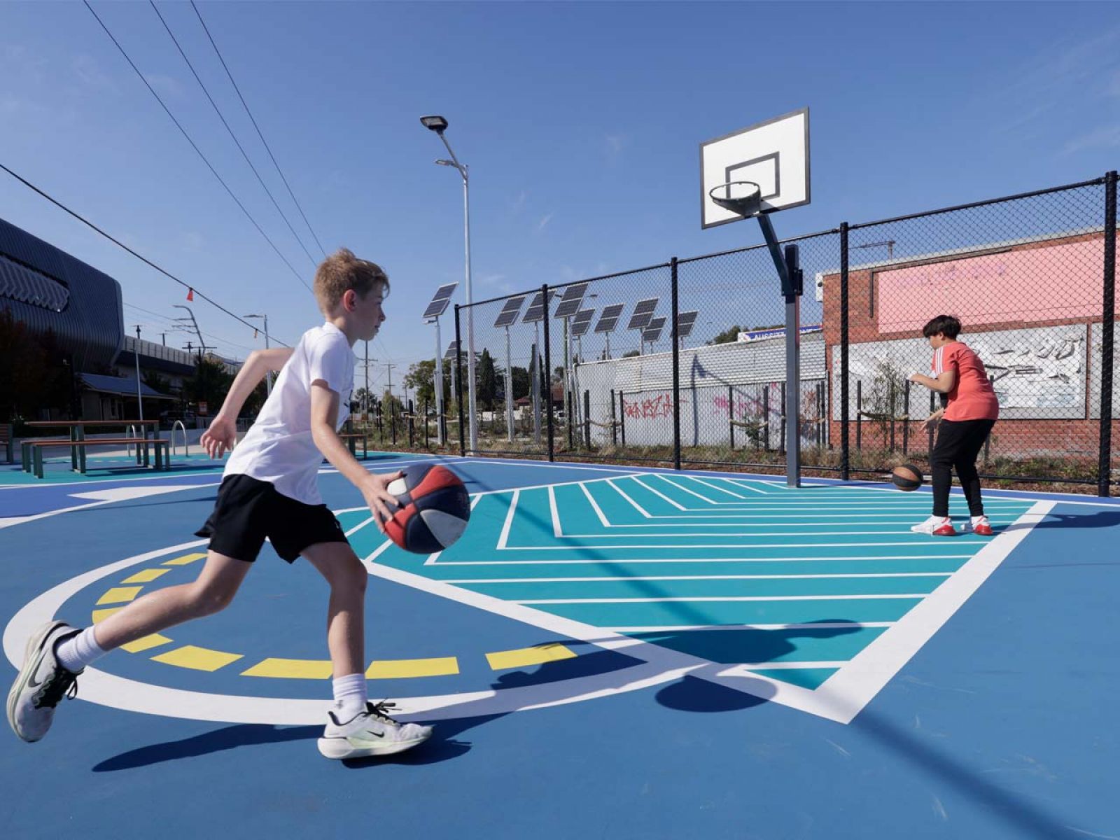 Child running up to take a shot on the basketball court.