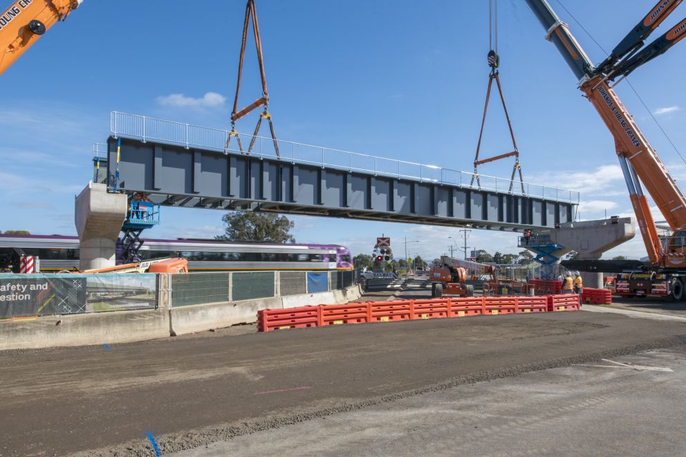 Steel bridge structure being lifted over the level crossing at Coburns Road