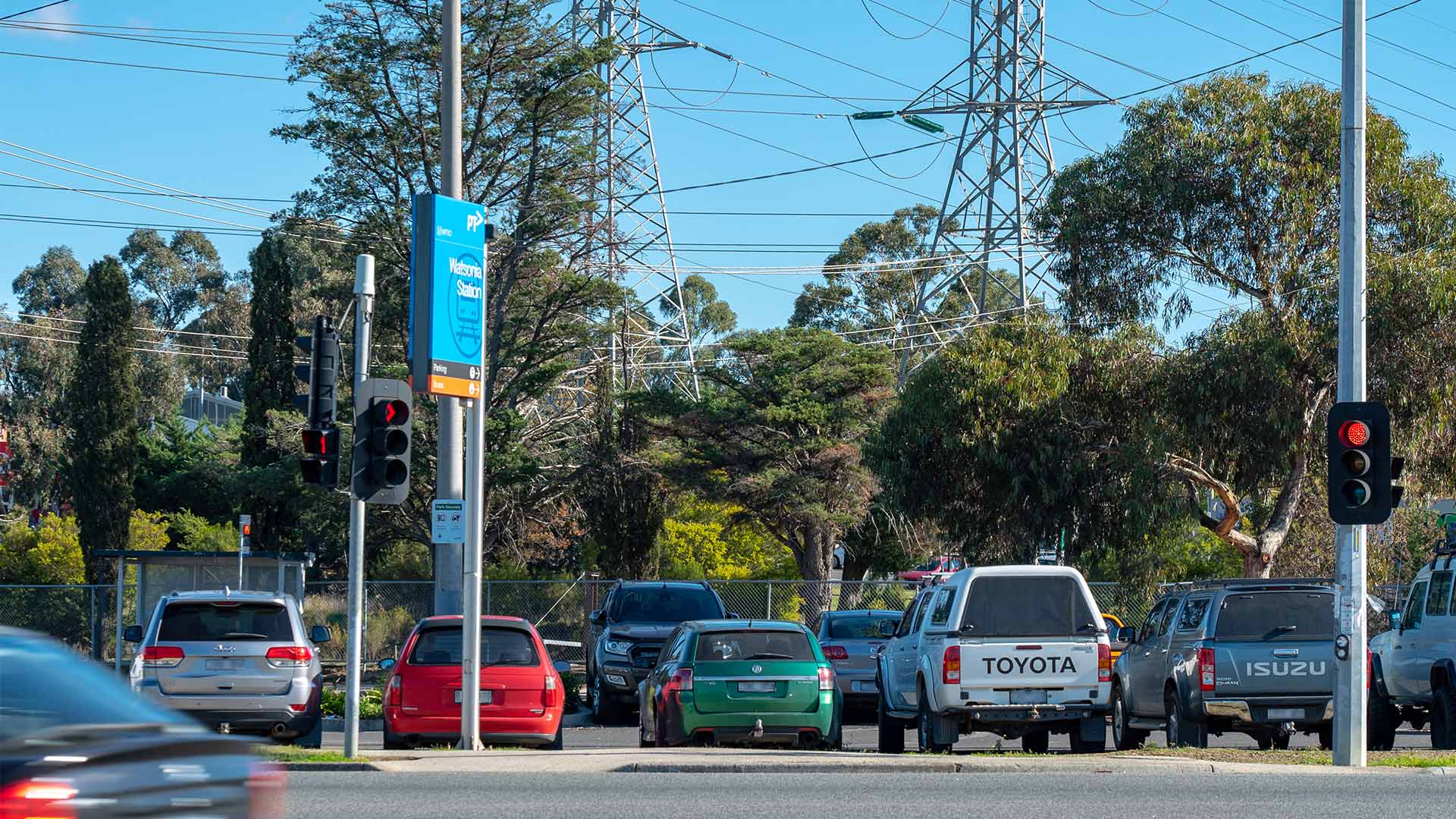 Watsonia Station car park and Greensborough Highway with vehicles parked at the station.