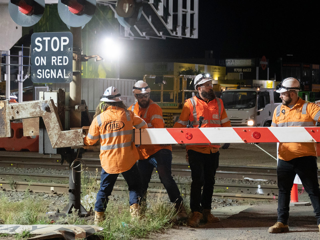 Three people removing a boom gate off at Hallam Road