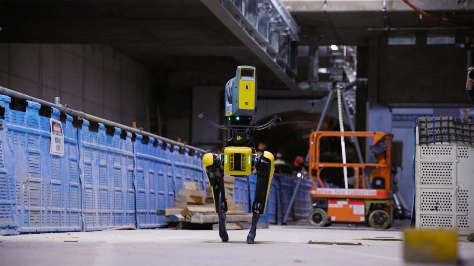 Close up of a yellow and grey robotic dog standing in a tunnel