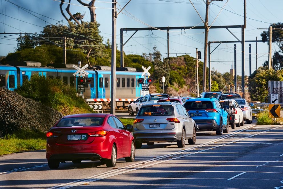 Traffic waiting at the Station Street, Aspendale level crossing as a train is passing through