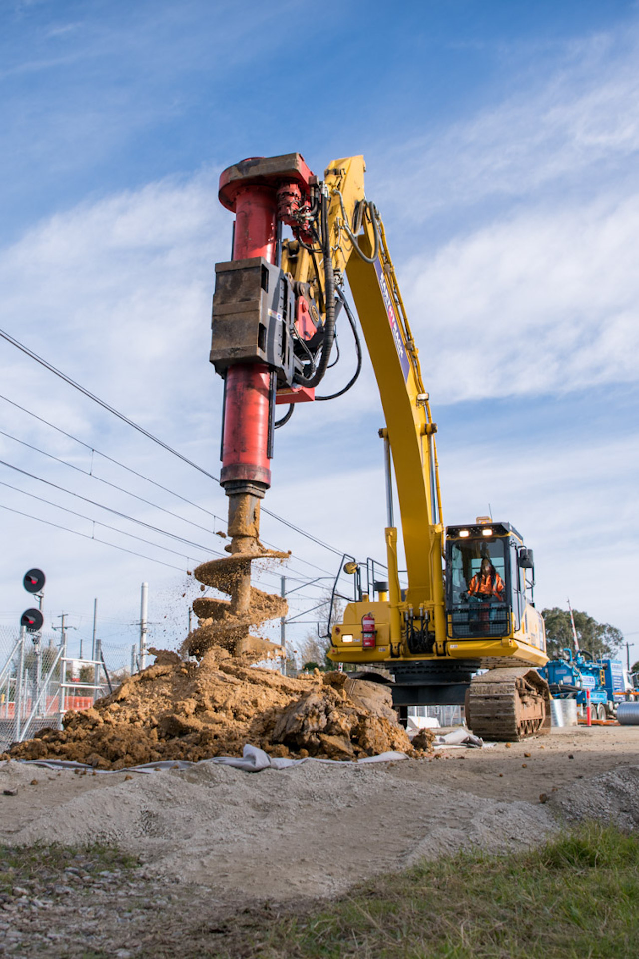 A large tall piling rig on site excavating soil.