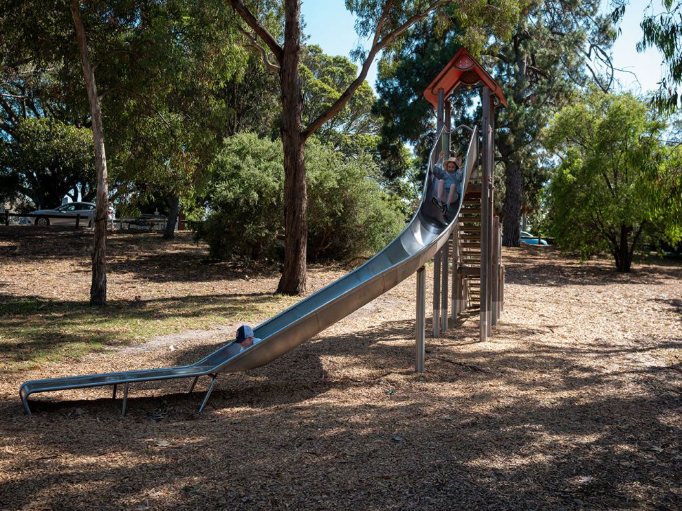 Two children enjoying the slide at Cheltenham Reserve