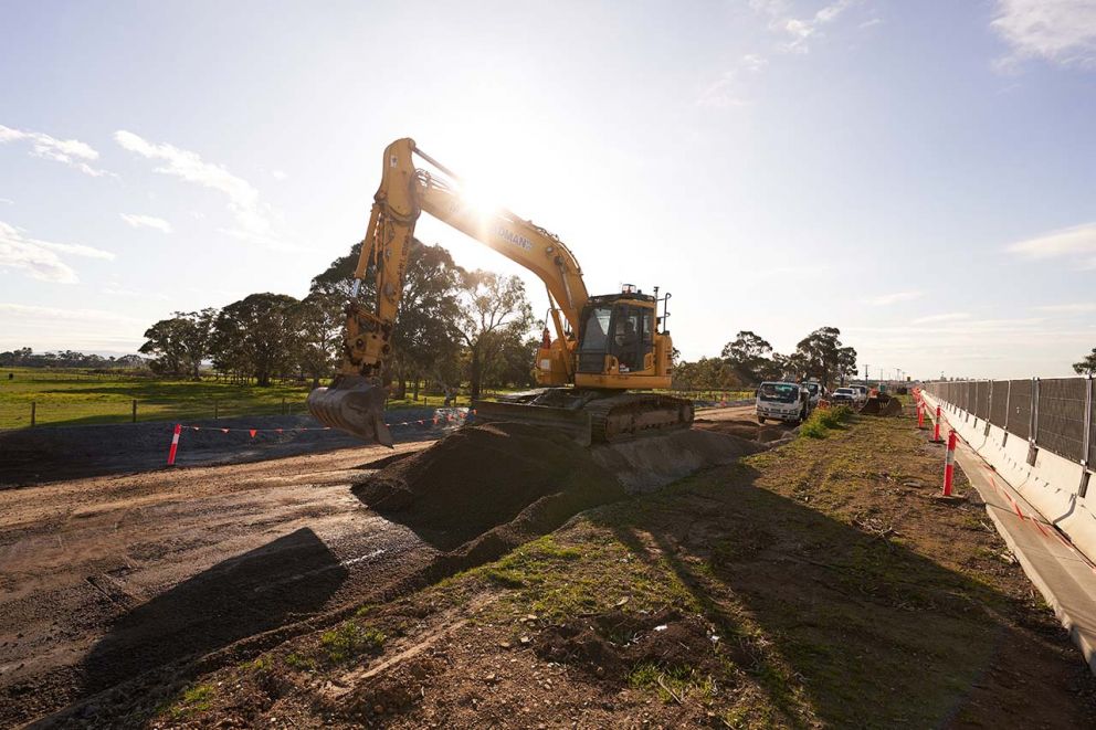 A digger lowering the ground levels in preparation for laying the road foundations