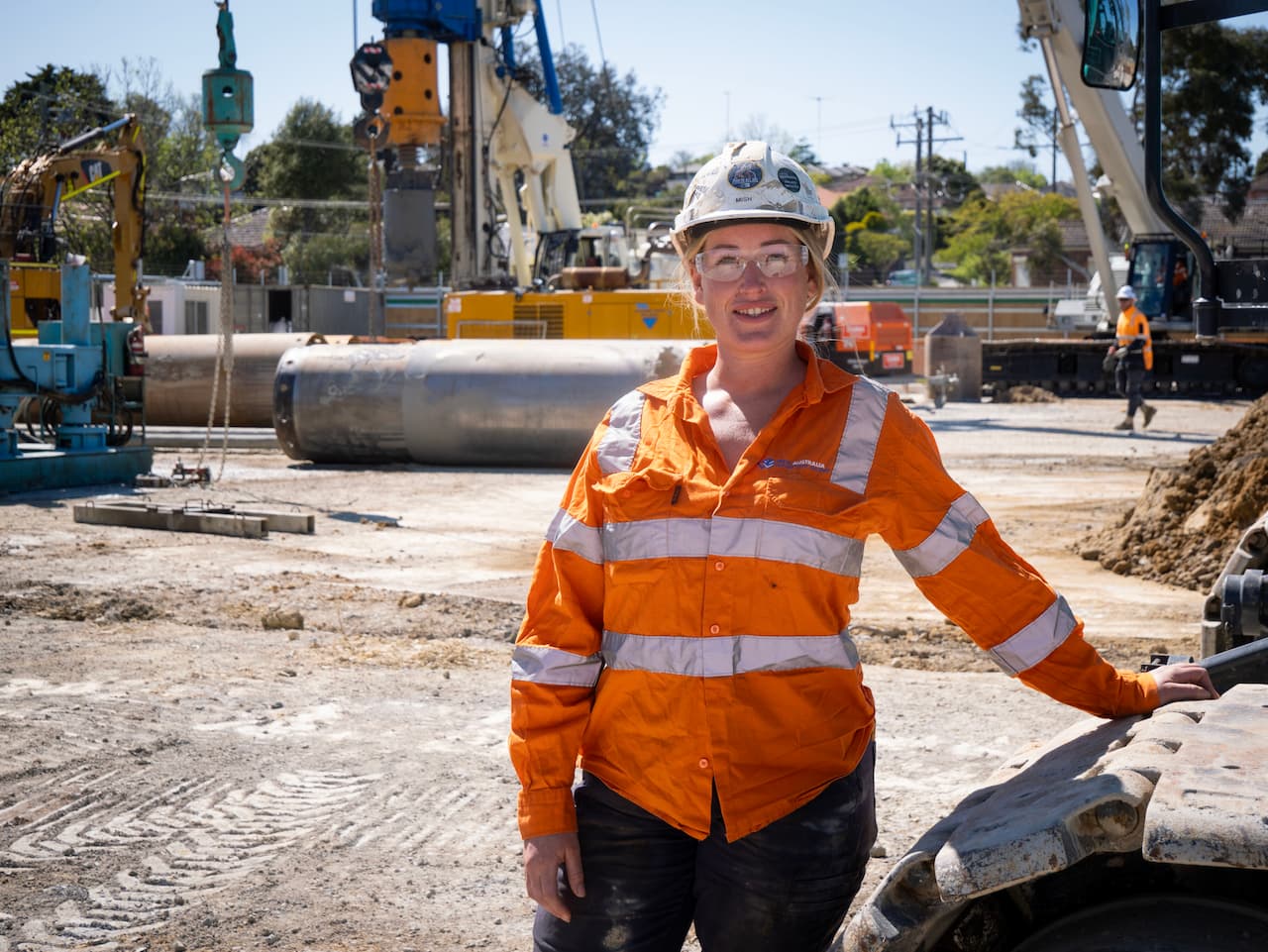 Excavator operator Michelle stands next to a digger on the SRL Burwood site.