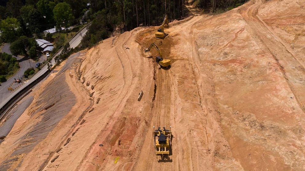 Earth moving machines continue clearing the middle section of the landslip