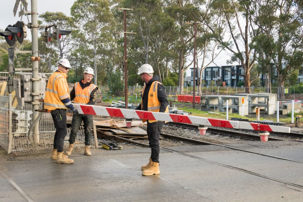 Three workers remove the Racecourse Road boom gates