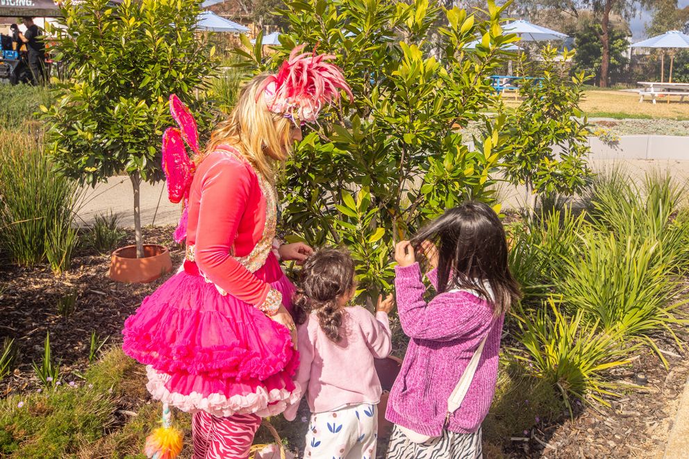 Woman dressed as a fairy interacting with children