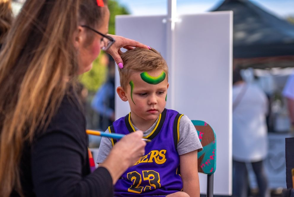 An attendee getting their face painted