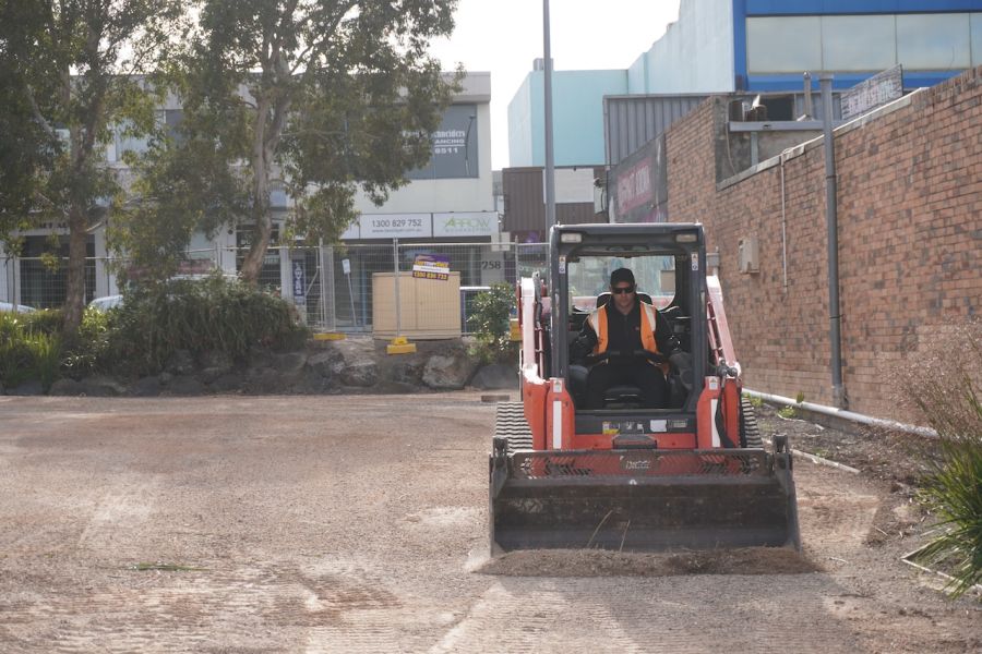 A worker in a track loader clears the ground for the Boronia Station Upgrade site office