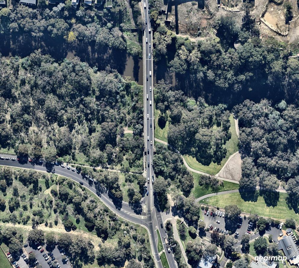 Chandler Highway prior to upgrade fro a birds-eye point of view. Road positioned in the middle surrounded by greenery