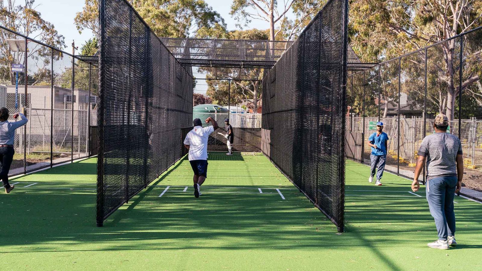 Players from Bellfield Cricket Club practicing bowling at batting in the new cricket practice nets.
