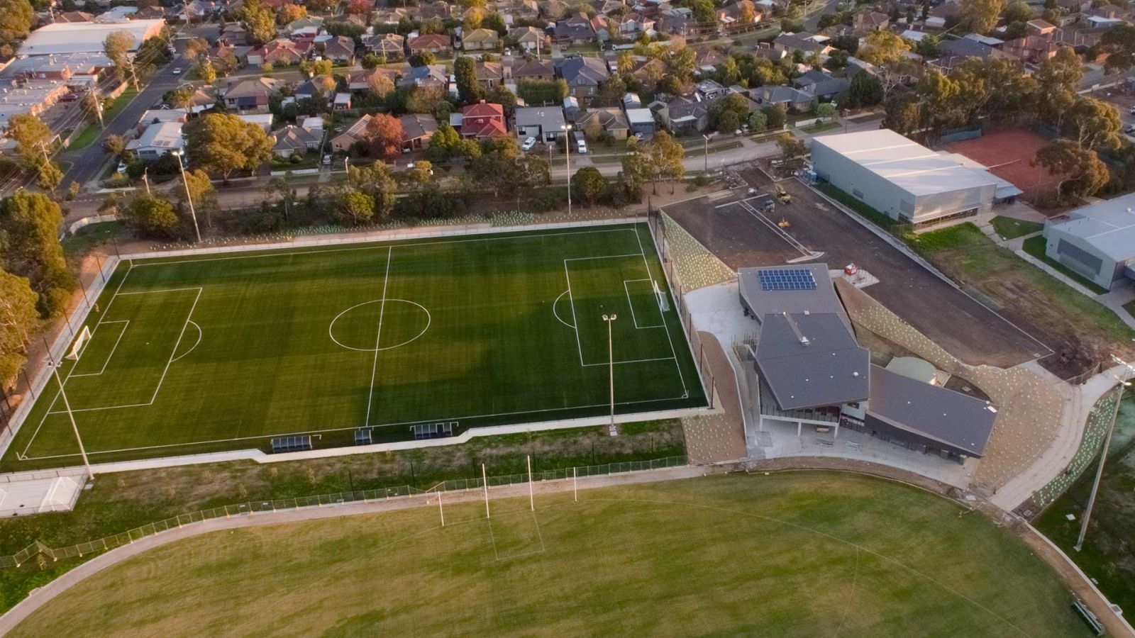Aerial view of new sports facilities at Greensborough College including soccer pitch, AFL oval and pavilion.