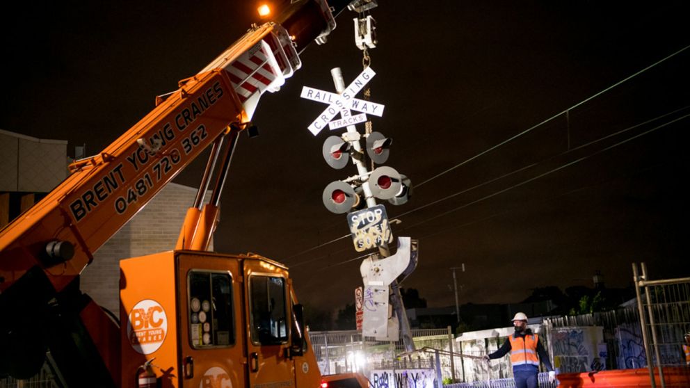 A crane removes the level crossing signage at Reynard Street