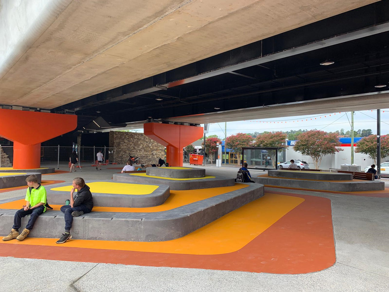 People sitting in the open space beneath the Lilydale Station.