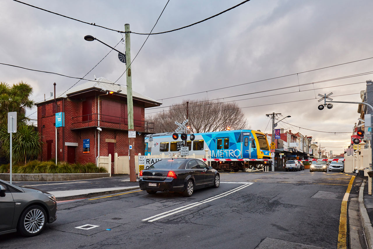 Traffic waiting at the Anderson Street level crossing as a train is passing through