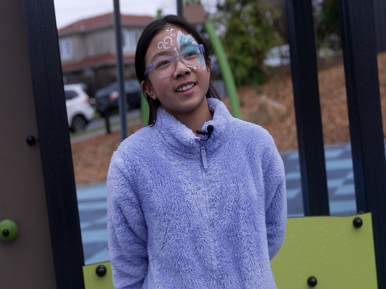 Girl with face painted  smiling in park