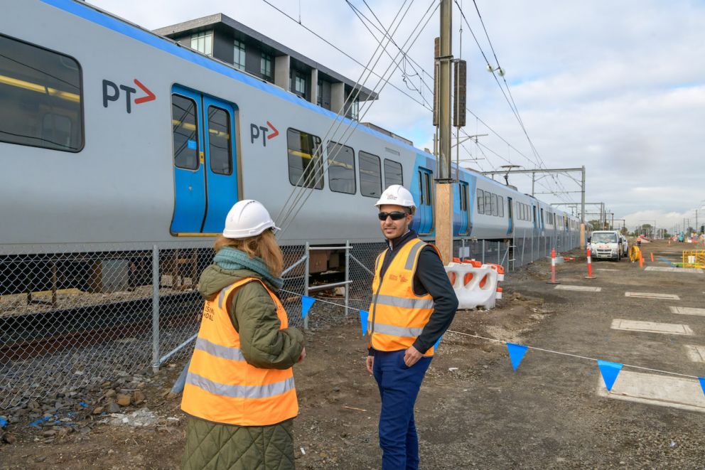 Hesham Al-Sharafi working on the Keon Parade Level Crossing Removal Project with train in background