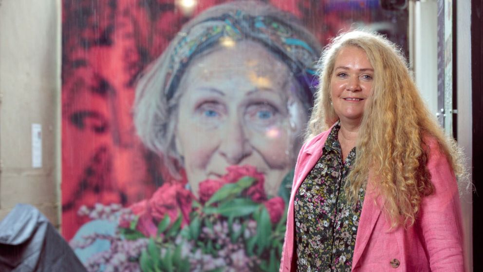 Image of Jane in front of her artwork in Scott Alley.