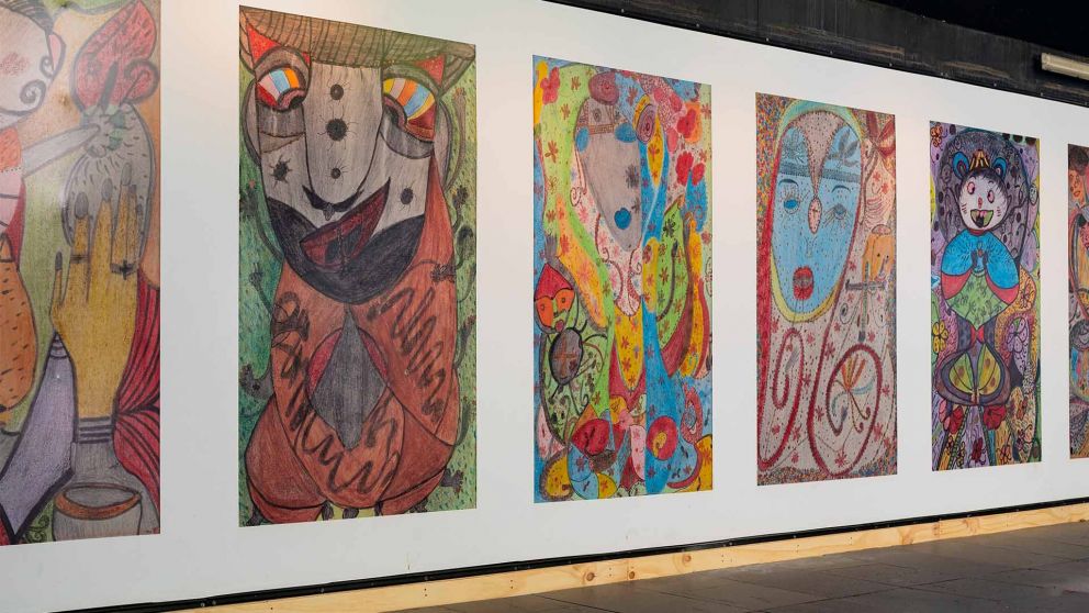 A row of colourful abstract portraits used as construction hoardings