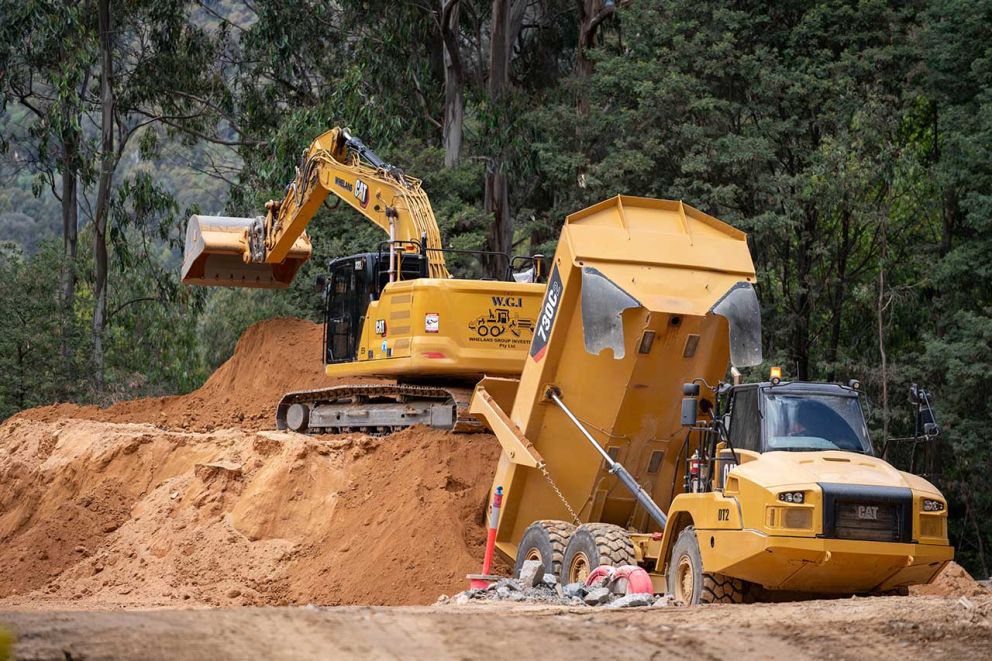 A moxy truck unloads material onto a stockpile