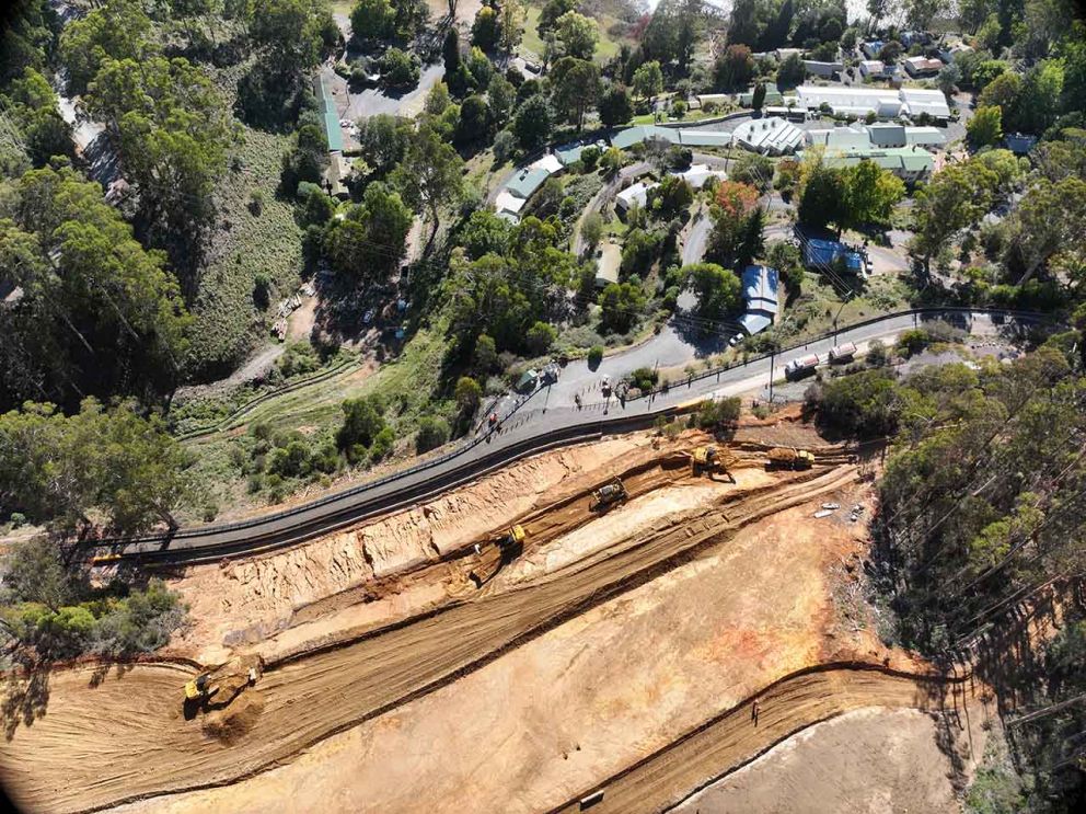 Aerial view showing machines clearing and shaping the final bench of the landslip