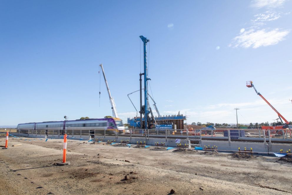 A train travels through the area as the team begin pouring the north abutment wall