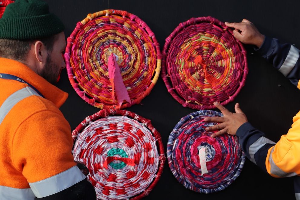 Workers install the woven wheels which make up the artwork PROGRESS