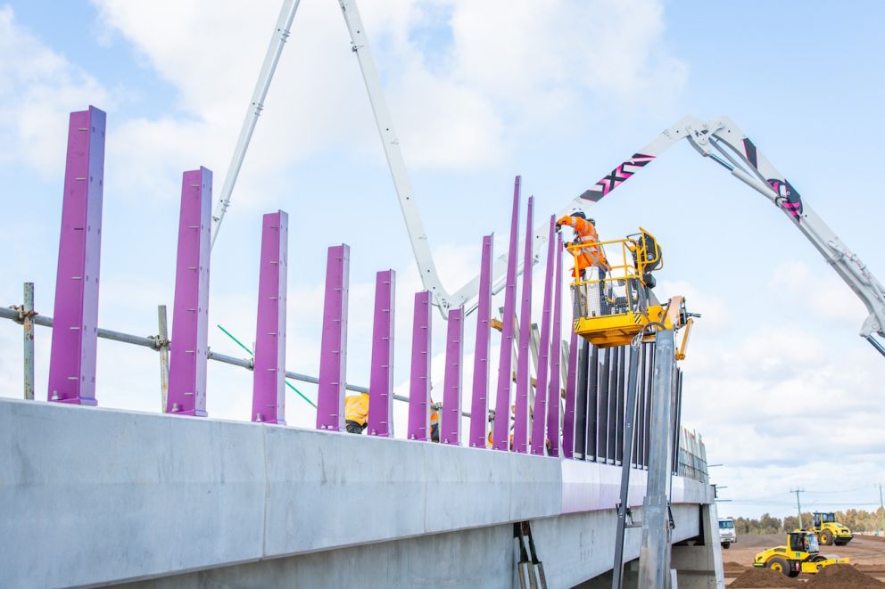 Crews install posts along the new Hopkins Road bridge in Truganina