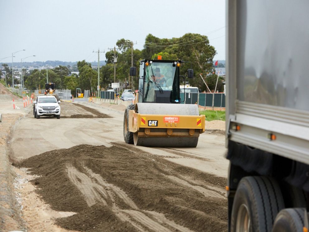 Image shows construction vehicles flatting the dirt for the new roads