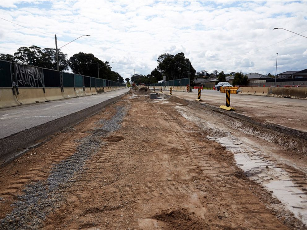 Image of the construction site with earth in the middle To the left of the image you can see the walking/cycling path completed