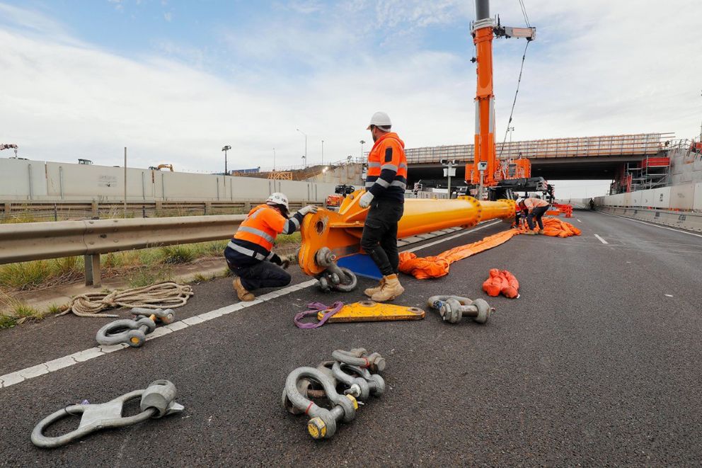 Construction workers setting up the crane spreader bar to complete beam lifts on O’Herns Road bridge