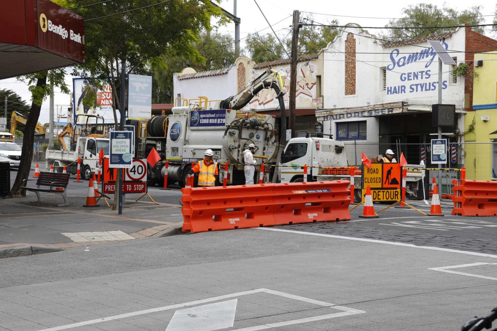 Road closed with site workers detouring traffic