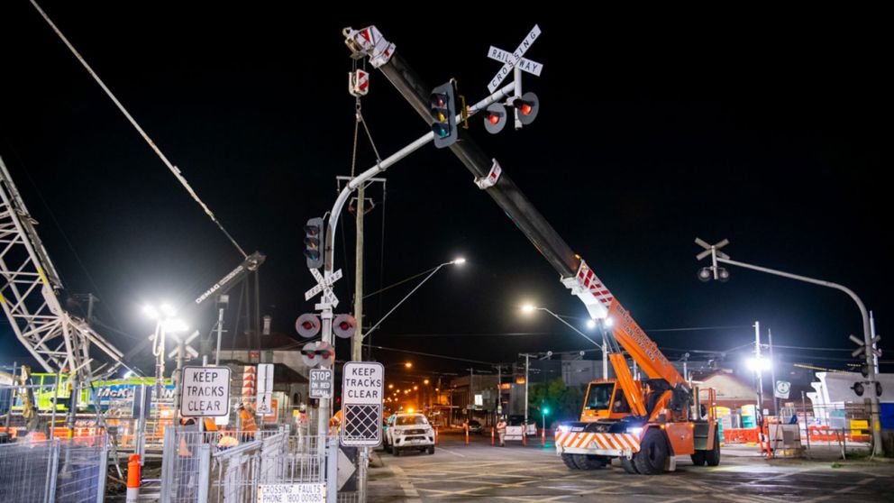 A crane removes the level crossing signage at Moreland Road