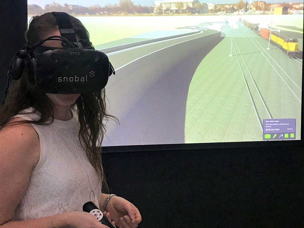A girl holding a virtual reality tool with VR headset on.