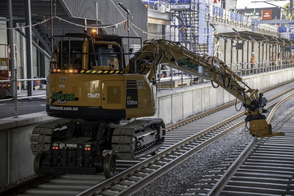 Lifting the long rail springs on to the sleepers in the rail trench