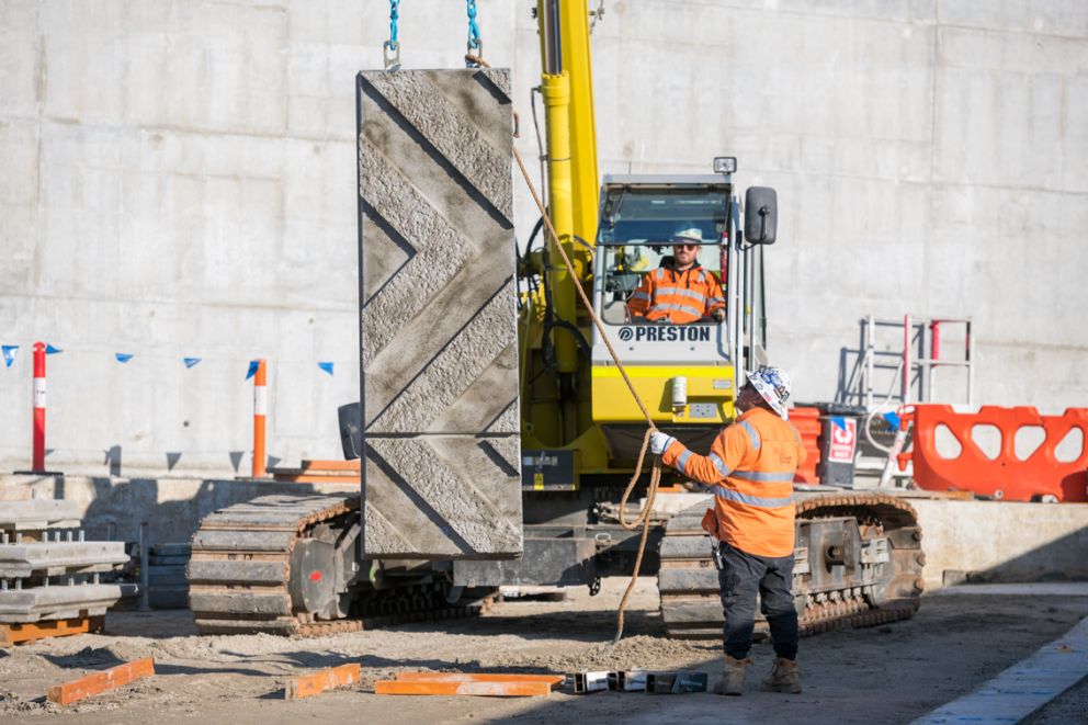 Crews lifting the patterned wall panels
