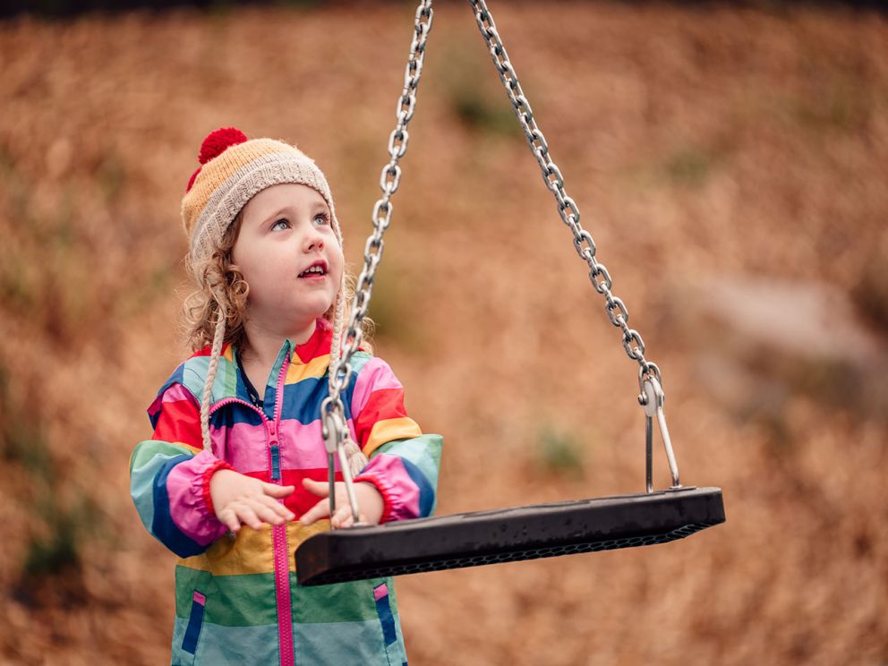 Child looking up at new swing set at Burwood Park