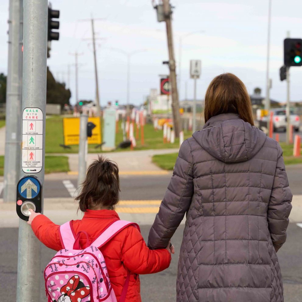 Women and child waiting at a pedestrian crossing