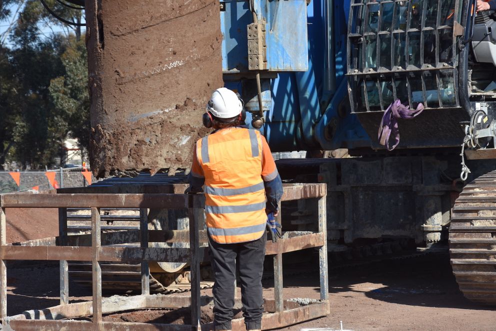 Worker inspecting piling rig