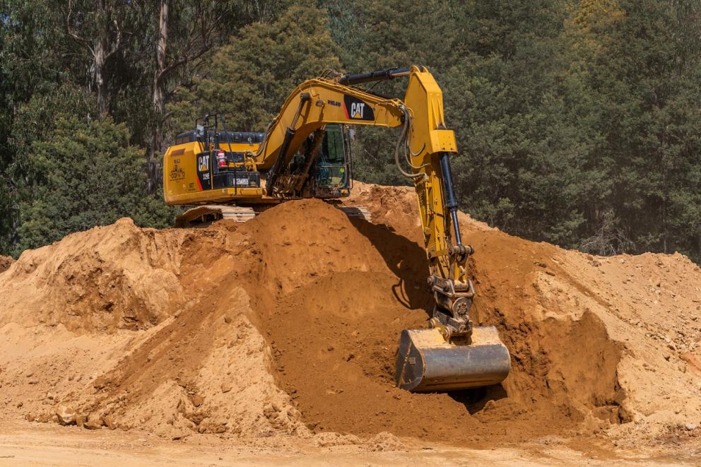 An excavator clearing material